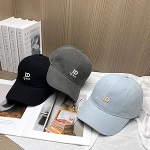 Detailed embroidery of ID letters on black, dark grey, and light blue baseball caps