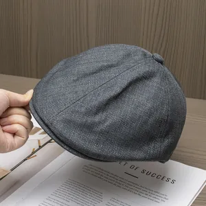 Detail der grauen Tweed-Stoffstruktur und des Knopfes auf der Rückseite dieser Schirmmütze