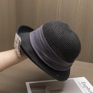 Détail d'un chapeau de paille tressé avec étiquette de protection UV et ruban gris chic