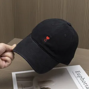 Close-up of black cotton baseball cap featuring red heart and C letter embroidery