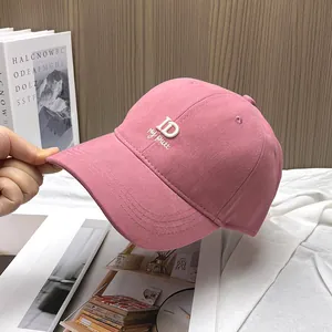 Close-up of pink cotton baseball cap with metallic ID logo and embroidered details
