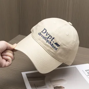 Détail de la broderie bleue sur la casquette en coton beige avec couture texturée