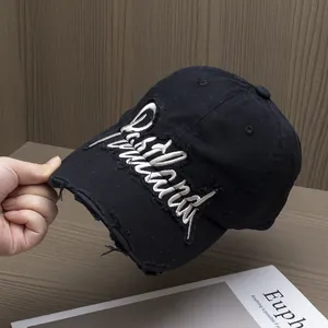 Dettaglio del cappello da baseball nero vintage con ricamo di lettere in 3D bianco