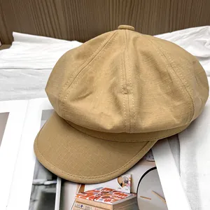 Detailed close-up of khaki newsboy hat with micro-grid texture and stitched octagonal crown
