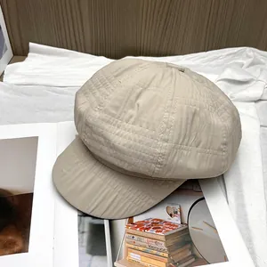 Detailopname van beige geplooide krantenbezorgerspet met geweven textuur