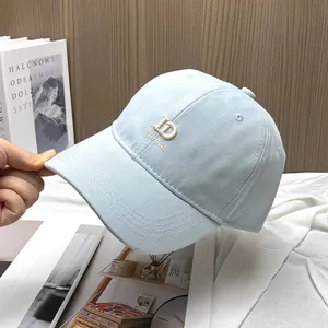 Detailed close-up of light blue baseball cap with white ID embroidery and 6-panel structure