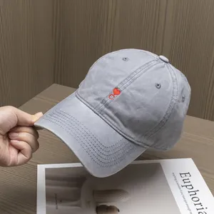 Close-up of red heart and C letter embroidery on a gray washed cotton baseball cap