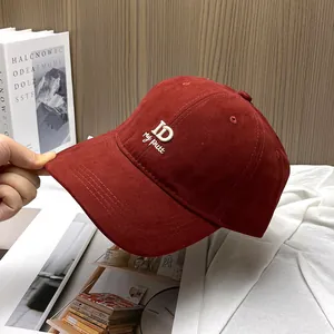 Detail of burgundy corduroy baseball cap with white ID my putt embroidery and soft texture