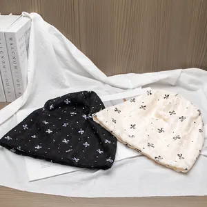 Soft cotton postpartum beanies in black and beige with elegant bow patterns for women