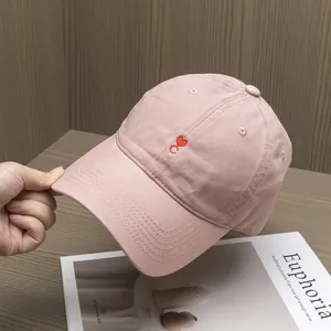 Close-up of soft pink twill cotton baseball cap with red heart embroidery on the front