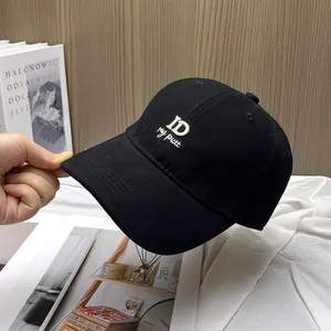 Detail of white ID letter embroidery on a premium black cotton twill baseball cap