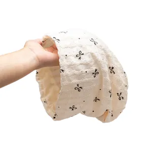 Breathable white cotton maternity hat with mesh texture and black bow patterns