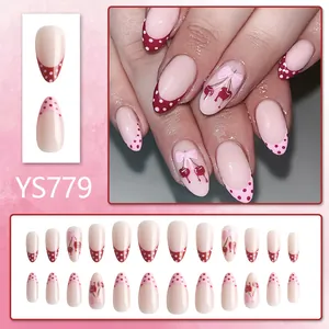 Almond-shaped press-on nails with red polka dot French tips and cherry bow designs
