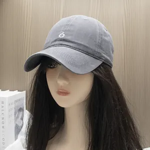 Close-up of grey cotton baseball cap featuring high-quality stitching and small round logo