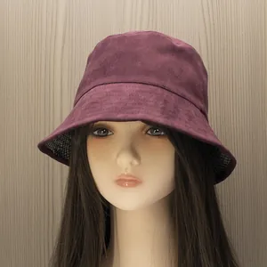 Detail view of burgundy faux suede bucket hat with black and white plaid lining