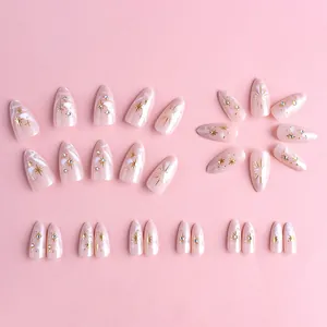 3D golden relief almond press-on nails with pink marble texture and glittery star accents