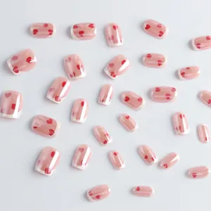 Glossy short square press-on nails with white French tips and red heart patterns
