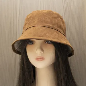 Detail of brown faux suede bucket hat featuring a classic houndstooth patterned lining