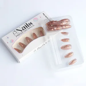 Detailed view of almond press-on nails with brown cat-eye effect and gold star patterns