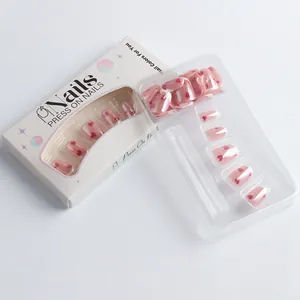 Detail of pink press-on nails with red hearts in original branded paper packaging