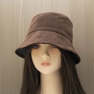 Detail view of brown cotton fisherman bucket hat on a mannequin head with wooden background