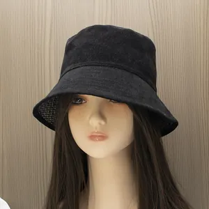 Detail of black canvas bucket hat showing decorative stitching and checkered lining