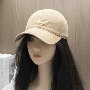 Detailed macro view of beige cotton baseball cap with white embroidery on mannequin