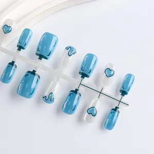Detail shot of cat eye blue and white heart pattern press-on nails on a plastic holder
