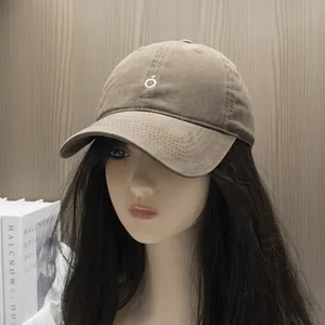 Close-up of khaki washed cotton baseball cap featuring embroidered white circular logo