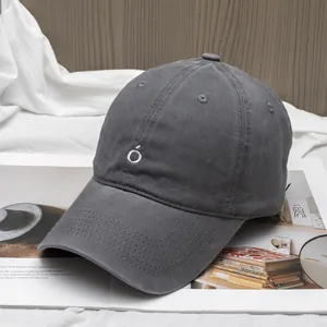 Detailed close-up of dark grey cotton baseball cap with white letter Ó embroidery