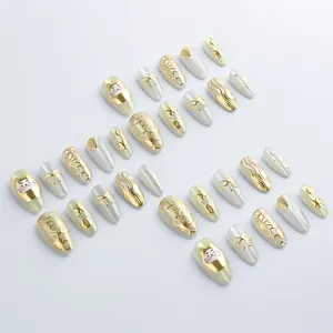 Faux ongles de luxe avec motifs dorés de chat et fleurs sur base nacrée