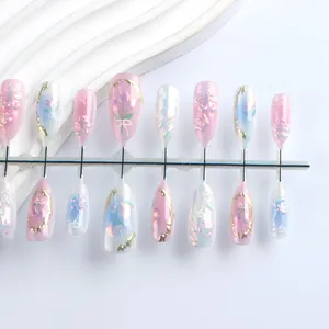 Détail de faux ongles amande avec reliefs floraux et finition œil de chat effet aurora