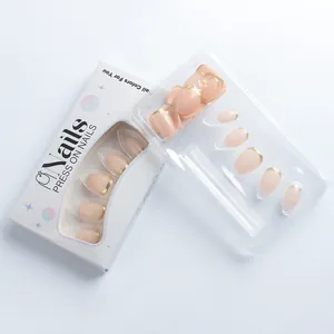 Detailansicht ovaler Nude-Mandel-Nägel zum Aufdrücken mit goldenen French-Spitzen in Box