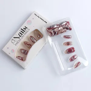 Detail view of dark red gothic press-on nails with 3D gold heart and eye patterns