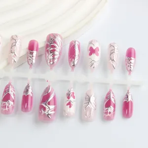 Detail of pink almond press-on nails with 3D silver thorn textures and butterfly motifs