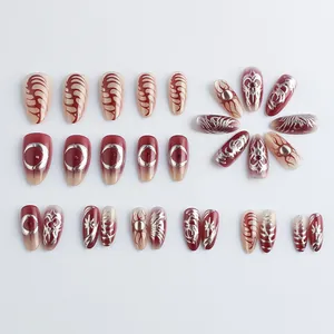 Deep red almond press-on nails with silver tribal totems and 3D metallic heart patterns