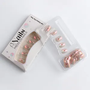 Detail of pink pearlescent press-on nails with red heart patterns in a white gift box