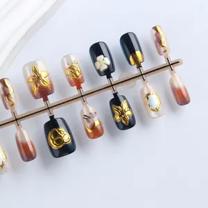 Detail view of cat-eye press-on nails with vintage gold relief and gradient patterns