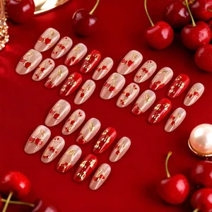 Short oval cat eye press-on nails featuring 3D gold cherry designs on red glossy base