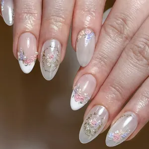 Close-up of almond fake nails with 3D embossed pink roses and gold vintage details