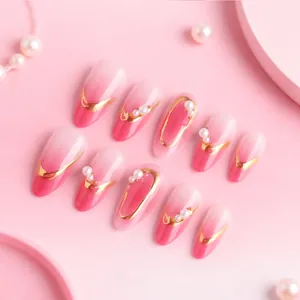 Pink gradient almond fake nails with golden edges and delicate pearl accents