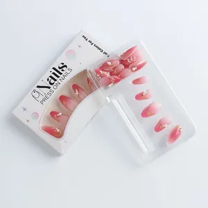 Detailed set of almond pink gradient press-on nails with gold accents and white pearls