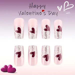 Dettaglio di unghie finte rosa con glitter argento e cuori rossi per San Valentino