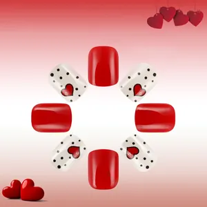 Short square press-on nails with red heart patterns and black dots in gloss finish