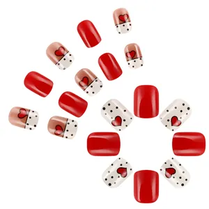 Short square press-on nails featuring red hearts, black polka dots and glossy red finish