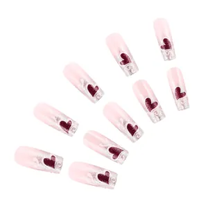 Dettaglio di unghie finte rosa con punte glitter argento e cuori rossi brillanti
