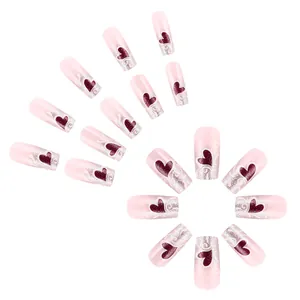 Unghie finte rosa con cuori rossi e brillantini argento su sfondo bianco neutro