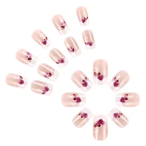Detail of glossy French tip press-on nails with purple and red heart patterns