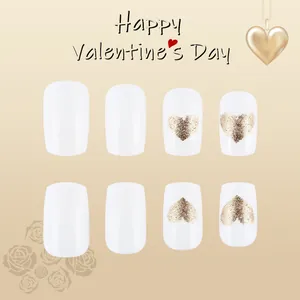 Detail view of white square-round press-on nails with golden glitter heart design
