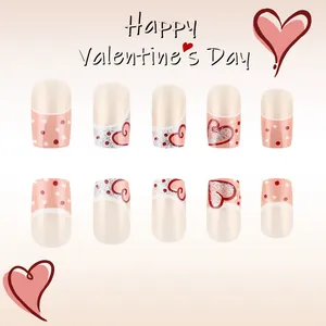 Dettaglio di unghie finte lucide stile French con cuori rossi e pois per San Valentino